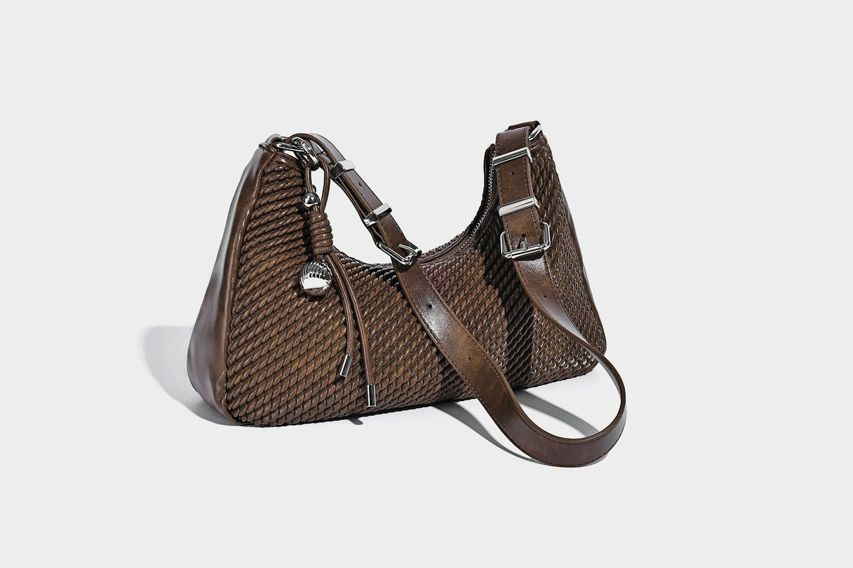 Woven crescent hobo shoulder bag with smooth side panels, zip-top closure, silver-tone charm hardware, and adjustable, detail