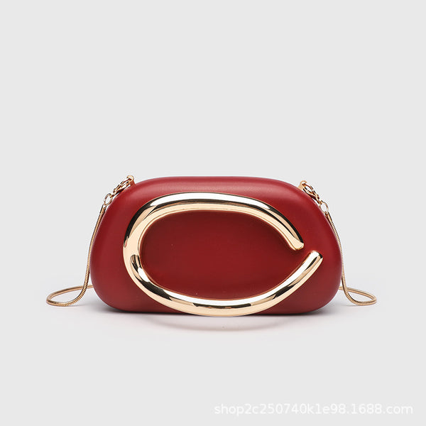 Kleine rechteckige Crossbody-Clutch mit abgerundeten Ecken, oversized poliertem C-förmigem Goldgriff und schmalem Goldkettenriemen, Detailansicht