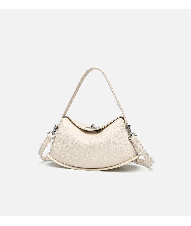 Pebbled leather-look half-moon saddle bag with turn-lock flap closure, top handle, and detachable crossbody strap, detail