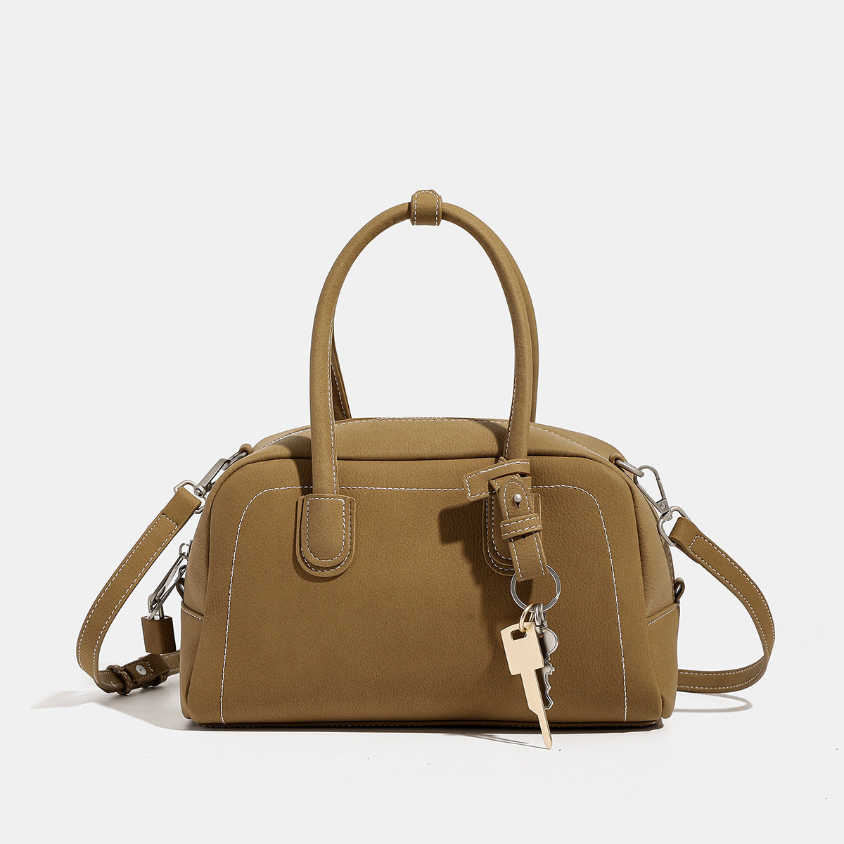 Kompakte, strukturierte Henkeltasche mit matter genarbter Oberfläche, geknoteten Doppelgriffen, goldenem Schlüsselanhänger und abnehmbarem, Detailansicht