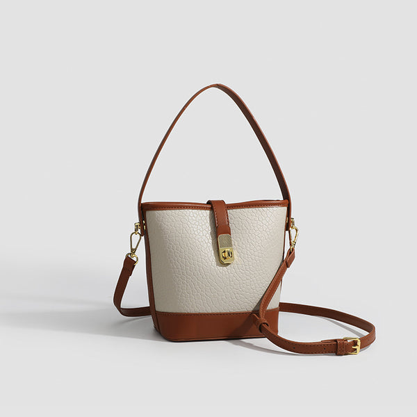 Formstabile zweifarbige Bucket Bag aus genarbtem Material mit goldfarbenem Drehverschluss und cognacfarbenem Besatz in Lederoptik, Detailansicht 3
