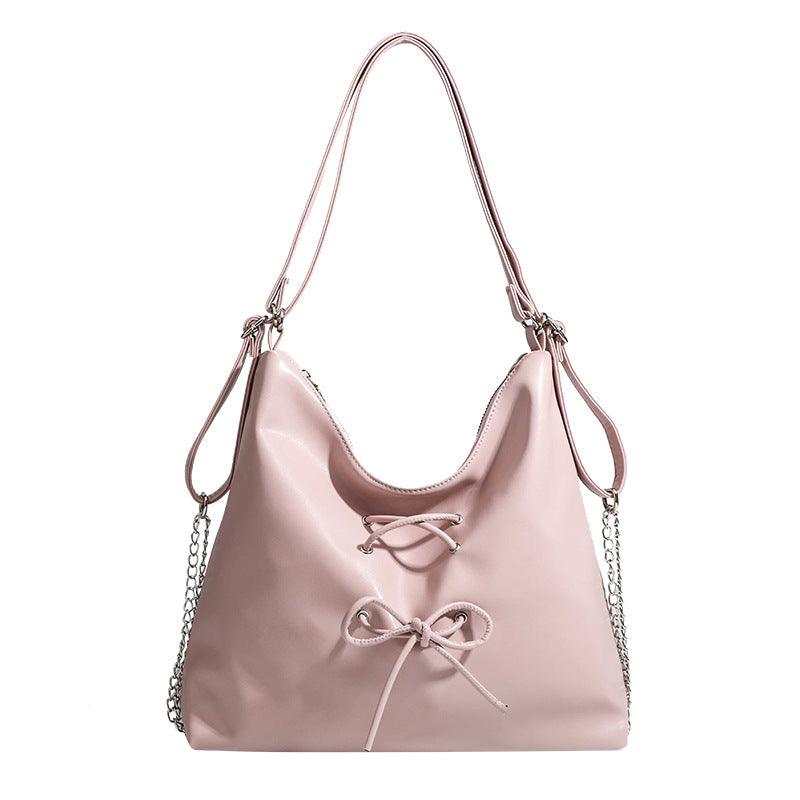 Glossy leather-look hobo shoulder bag with front bow lacing detail and silver-tone chain strap, detail view 5