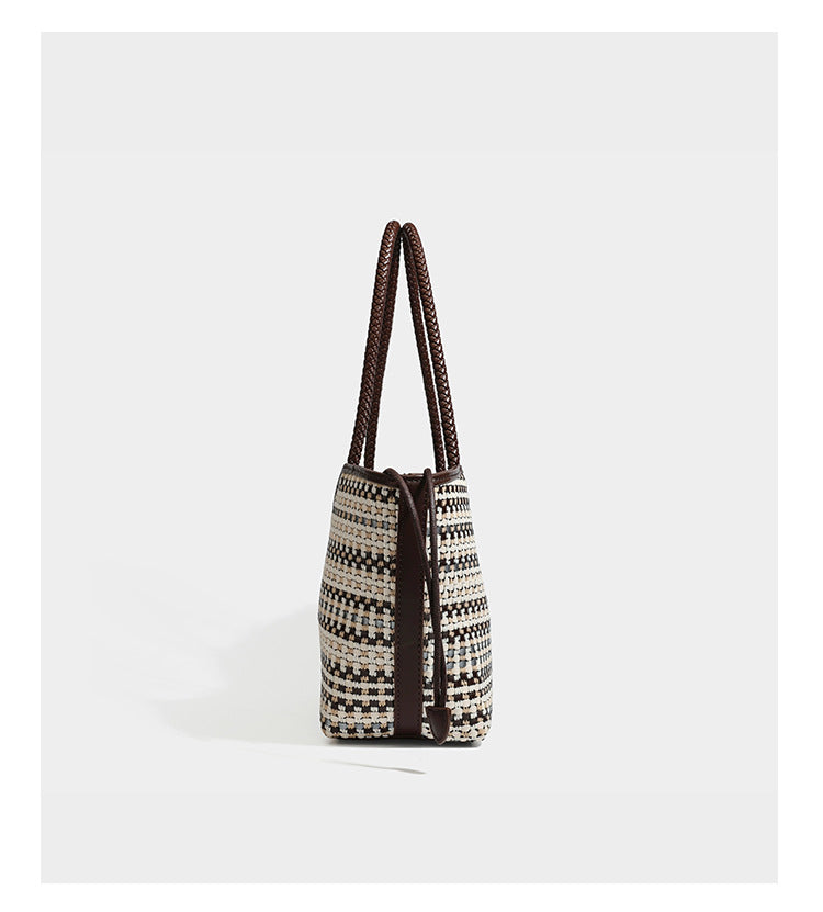 Large woven checker-pattern tote bag with dark braided shoulder straps, leather-look trim, and drawstring side ties, detail