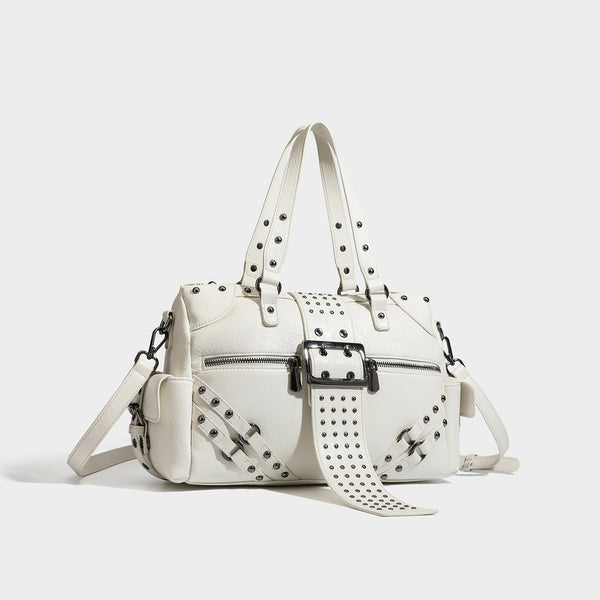 Structured pink leather-look satchel bag with gunmetal studded trim, rectangular buckle strap, dual top handles, and, detail
