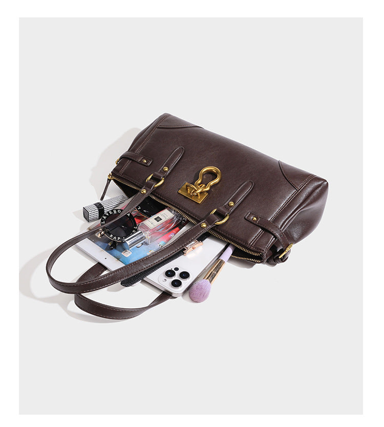 Strukturierte dunkelbraune Satchel-Tote in Lederoptik mit Ringverschluss in Antikgold-Optik, zwei Henkeln und seitlichem Riemen mit Schnalle