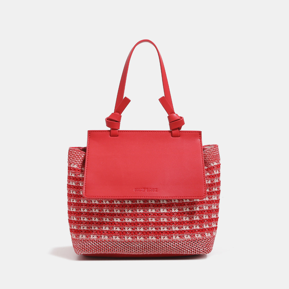 Structured woven tote bag with smooth leather-look front flap panel, knotted top handles, and detachable crossbody strap