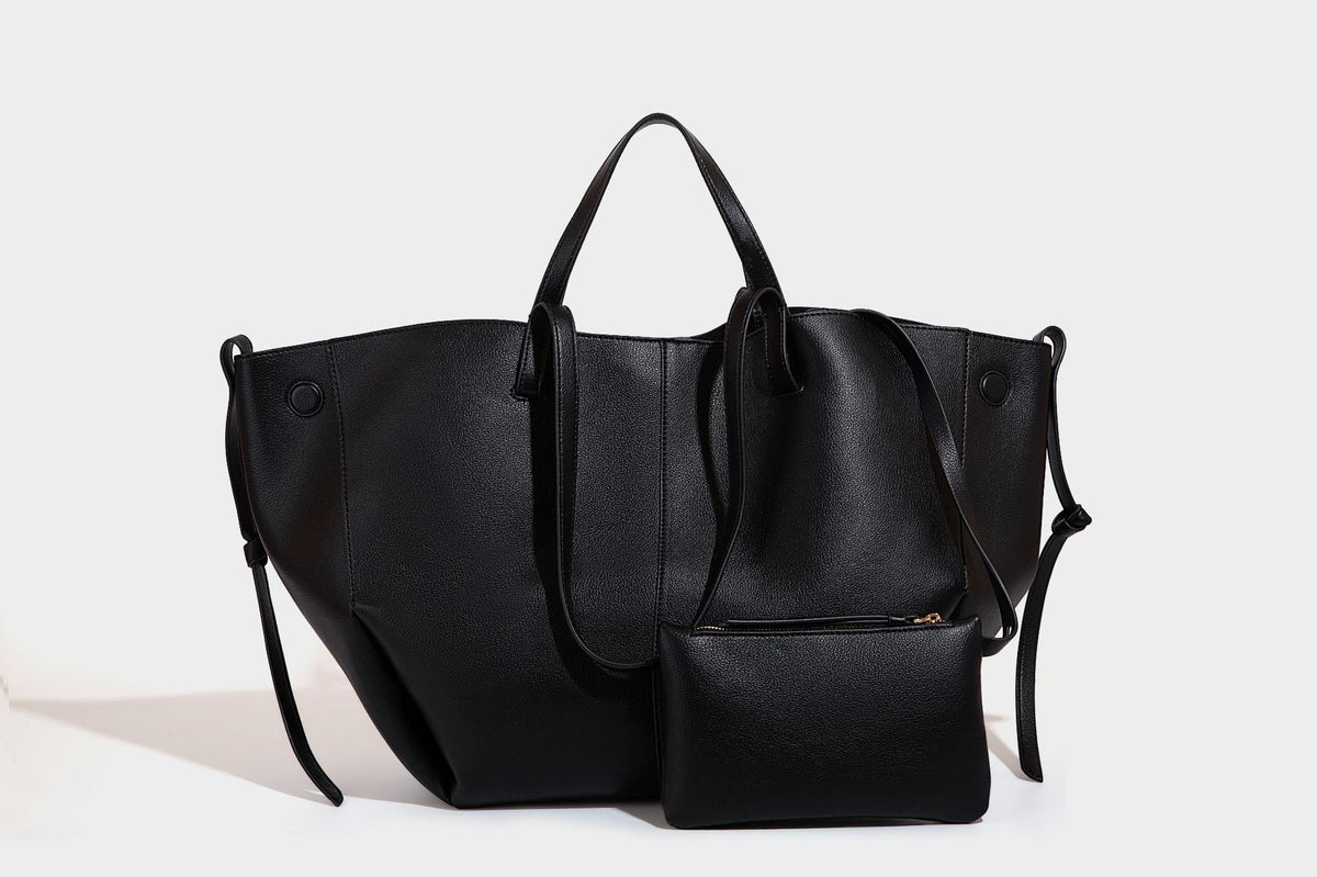 Große, formstabile trapezförmige Tote-Bag aus braunem Lederimitat mit genarbter Oberfläche, zwei Tragegriffen und seitlichen Bindebändern, Detail