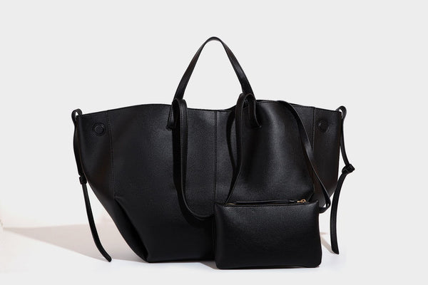 Große, formstabile trapezförmige Tote-Bag aus braunem Lederimitat mit genarbter Oberfläche, zwei Tragegriffen und seitlichen Bindebändern, Detail