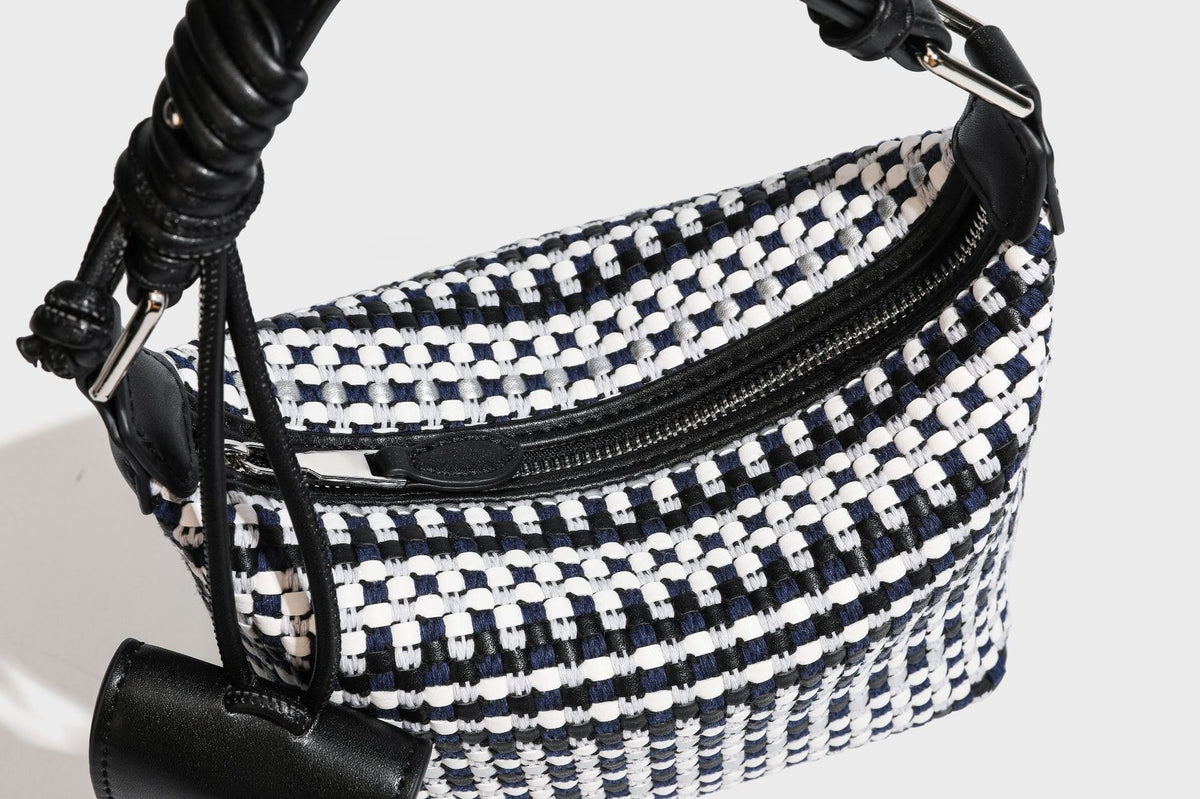 Small crescent shoulder bag in black-and-white woven textile with smooth black leather-look trim, zip-top closure, knotted