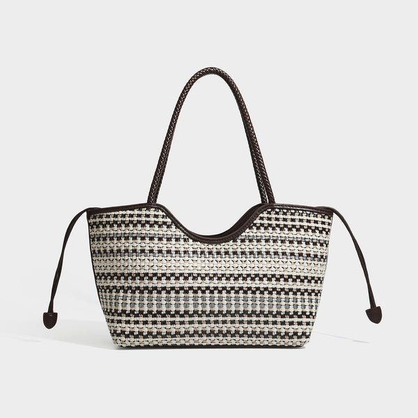 Large woven checker-pattern tote bag with dark braided shoulder straps, leather-look trim, and drawstring side ties, detail