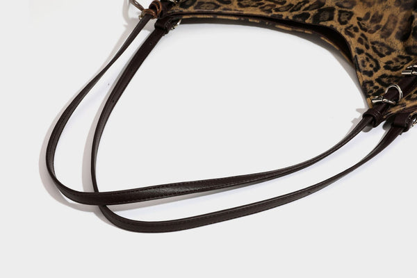 Slouchy leopard-print shoulder tote bag in tan and brown with long double straps, side tie straps, and dangling charm, detail