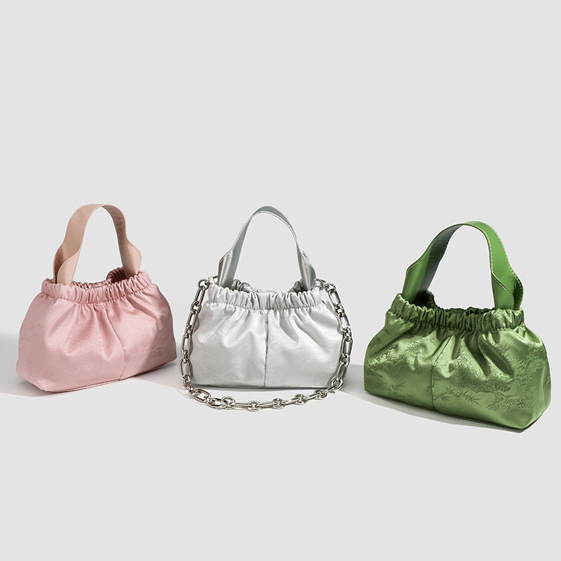Small ruched satin-finish cloud bag with elasticized drawstring top, short top handle, and chunky silver-tone chain strap