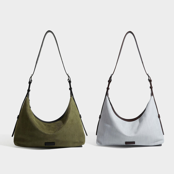 Slouchy olive green canvas hobo shoulder bag with black leather-look trim, zip-top closure, and adjustable strap, detail view