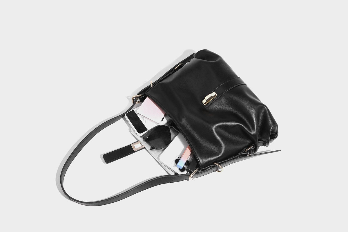 Soft slouchy hobo shoulder bag with smooth leather-look finish, gold-tone buckle and tab hardware, and long adjustable strap
