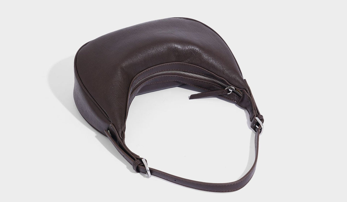 Crescent half-moon shoulder bag in pebbled leather-look finish with adjustable strap and silver-tone hardware, detail view 33