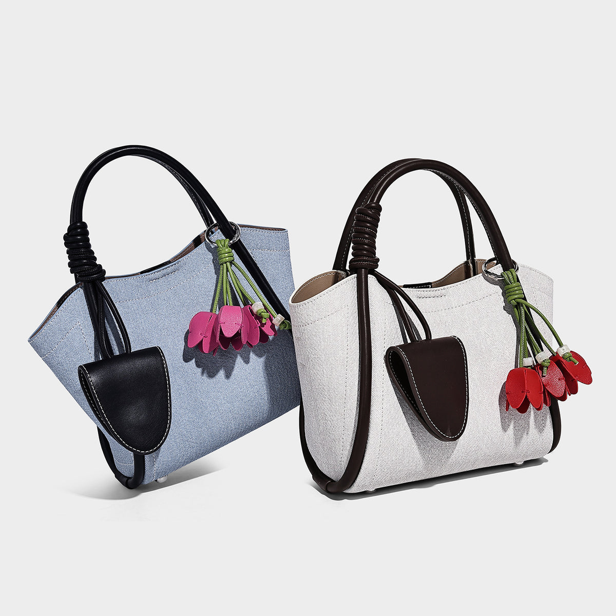 Light blue denim trapezoid tote bag with black leather-look trim, knotted top handles, detachable crossbody strap, front