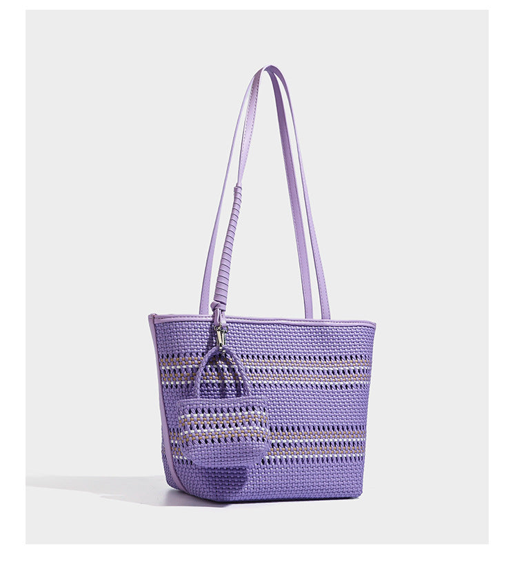 Large structured woven tote bag with striped basket-weave finish, long shoulder straps, and detachable mini pouch charm