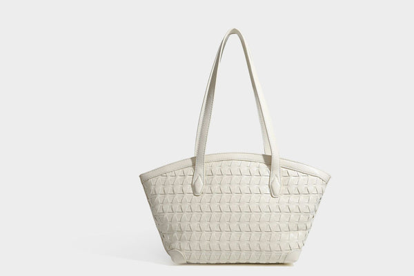 Large leather-look tote bag with geometric woven emboss, double shoulder straps, and round woven cord charm in brown, detail