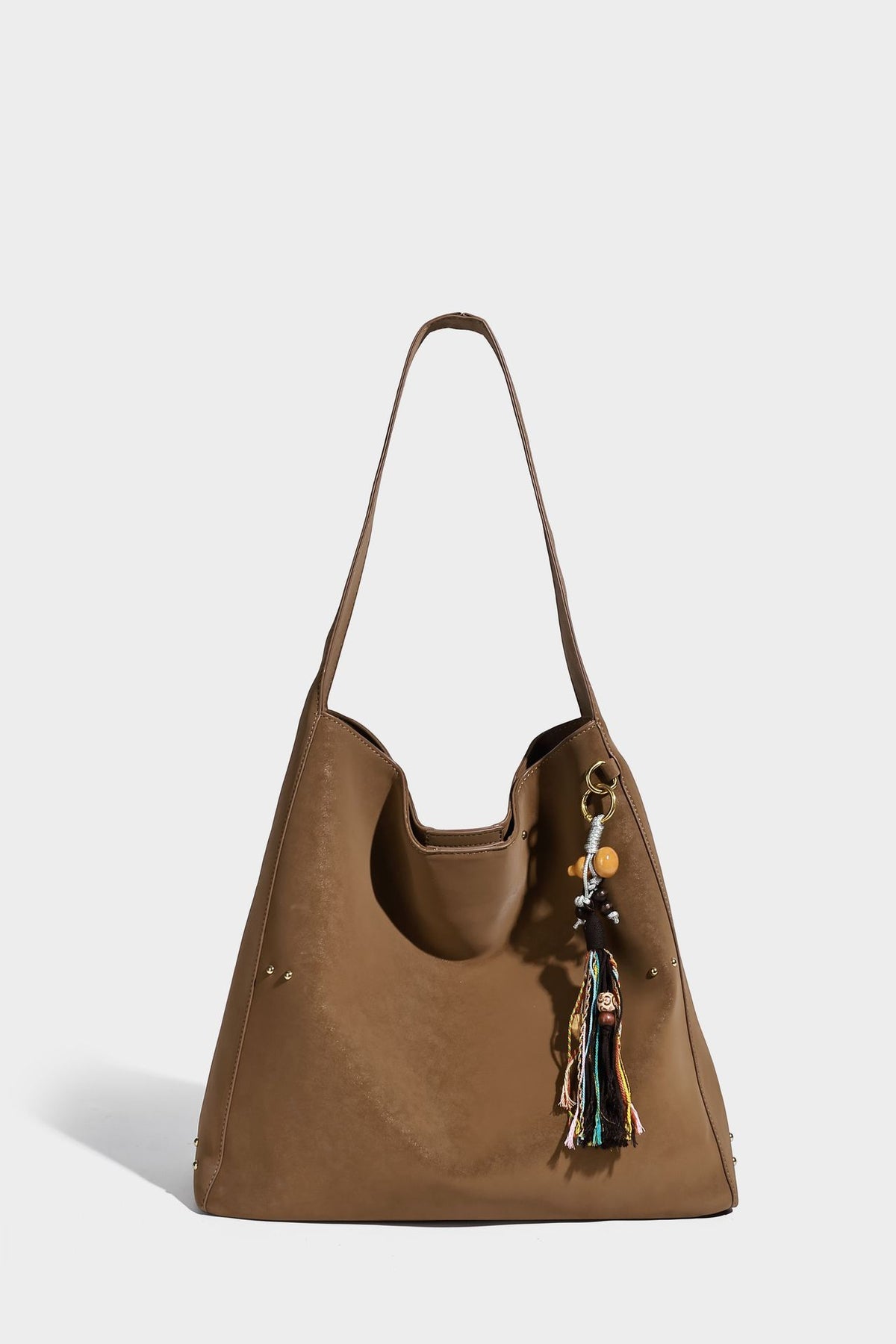 Oversized trapezoid tote bag with matte leather-look finish, gold-tone rivets, and long shoulder strap, detail view 11