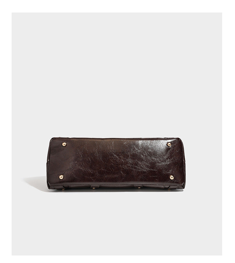 Glossy dark brown structured Boston satchel with heart-shaped lock charm, star pendant, rivet studs, multi-strap front panel