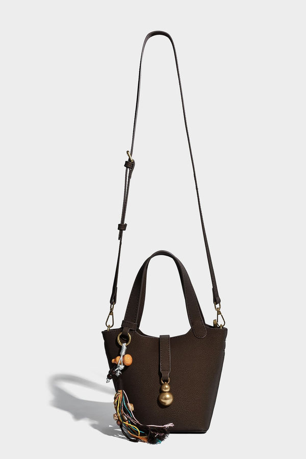 Kleine matte Beuteltasche mit genarbter Oberfläche, antikgoldfarbenen Ringbeschlägen, Perlen- und Quastenanhänger, kurzen Tragegriffen oben und