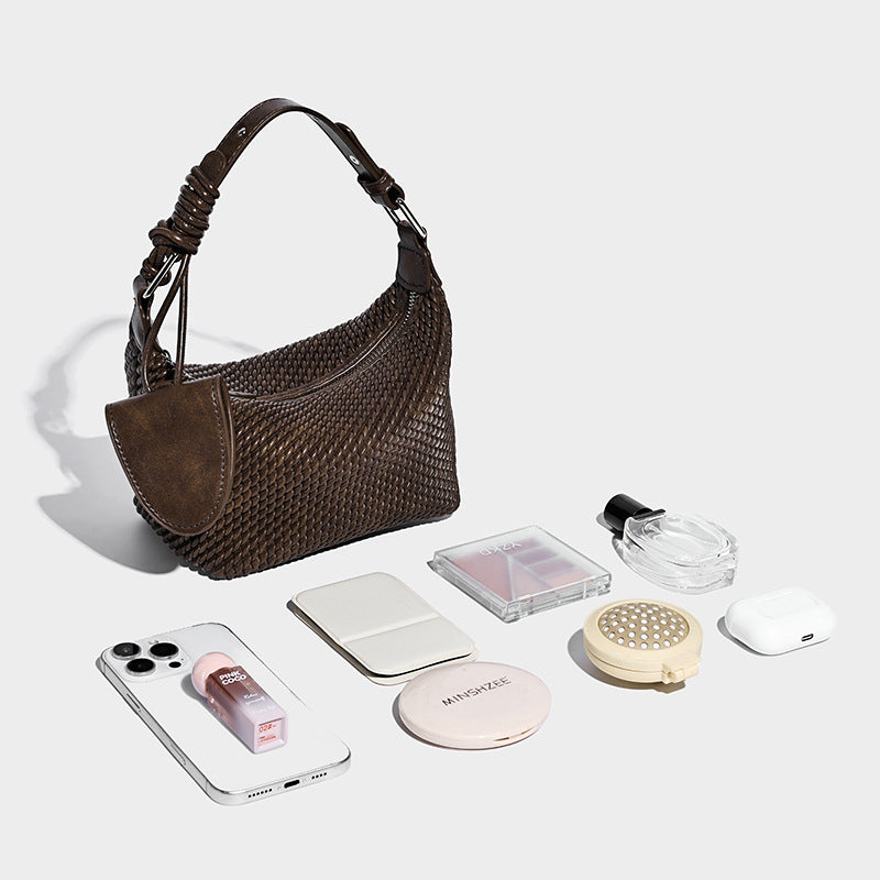 Halbmondförmige Hobo-Schultertasche in gewebter Optik mit geknotetem Tragegriff, integrierter Mini-Klappentasche und verstellbarem Träger in warmen
