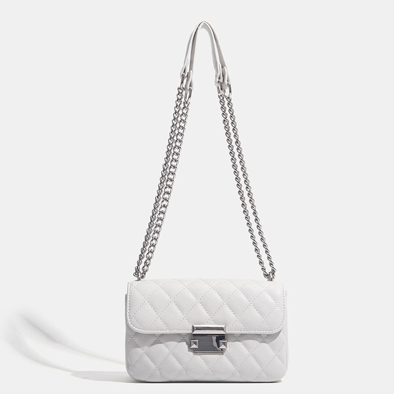 Kleine strukturierte Schultertasche mit Rautensteppung, doppeltem silberfarbenem Kettenriemen und rechteckigem silberfarbenem Verschluss, Detailansicht