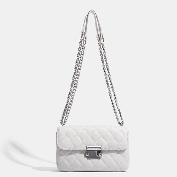 Kleine strukturierte Schultertasche mit Rautensteppung, doppeltem silberfarbenem Kettenriemen und rechteckigem silberfarbenem Verschluss, Detailansicht