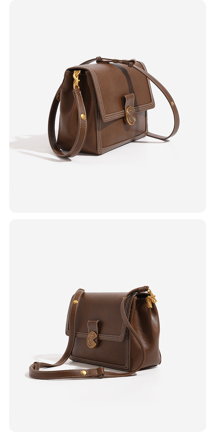 Structured flap shoulder bag with gold-tone circular turn-lock closure, white contrast stitching, and adjustable strap