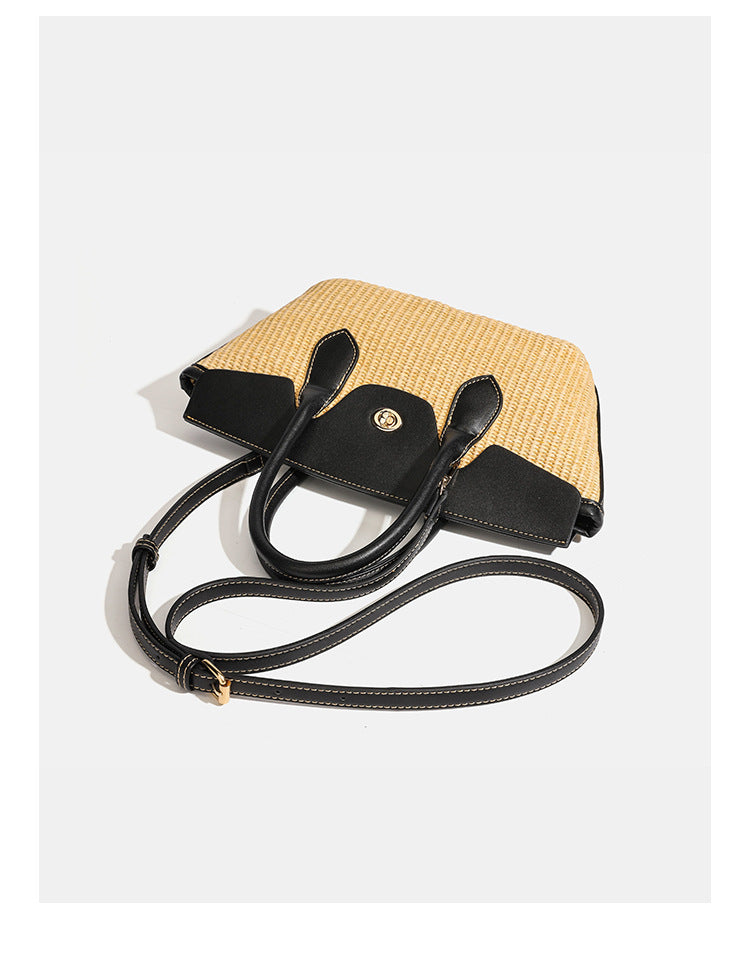Structured tan woven straw tote bag with black leather-look trim, twin rounded top handles, gold-tone turn-lock front flap