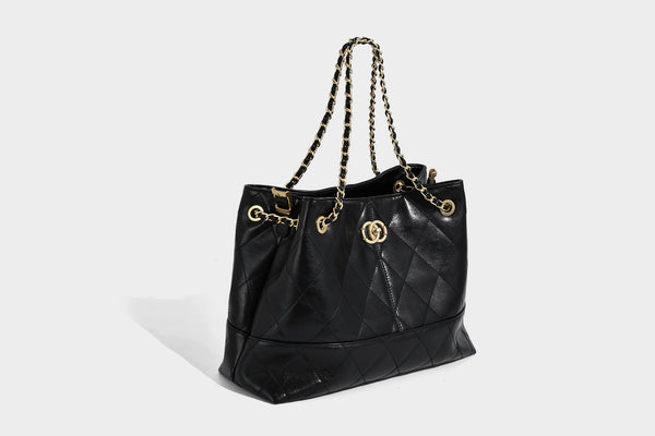 Gesteppte zweifarbige Schultertasche mit goldfarbener Kettenriemen und ineinandergreifendem Ringemblem im apricot-schwarzen Colorblock-Design, Detailansicht