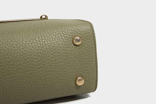 Small structured pebbled flap mini satchel with gold-tone bar hardware, short top handle, and detachable crossbody strap