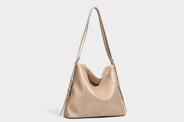Große, lässig fallende Hobo-Schultertasche in glänzender, geknautschter Lederoptik mit goldfarbenen Beschlägen und langem, verstellbarem Riemen