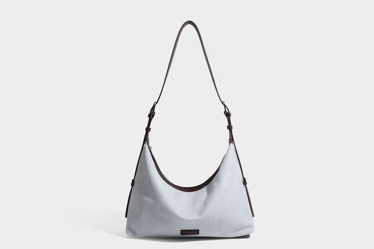 Slouchy olive green canvas hobo shoulder bag with black leather-look trim, zip-top closure, and adjustable strap, detail view