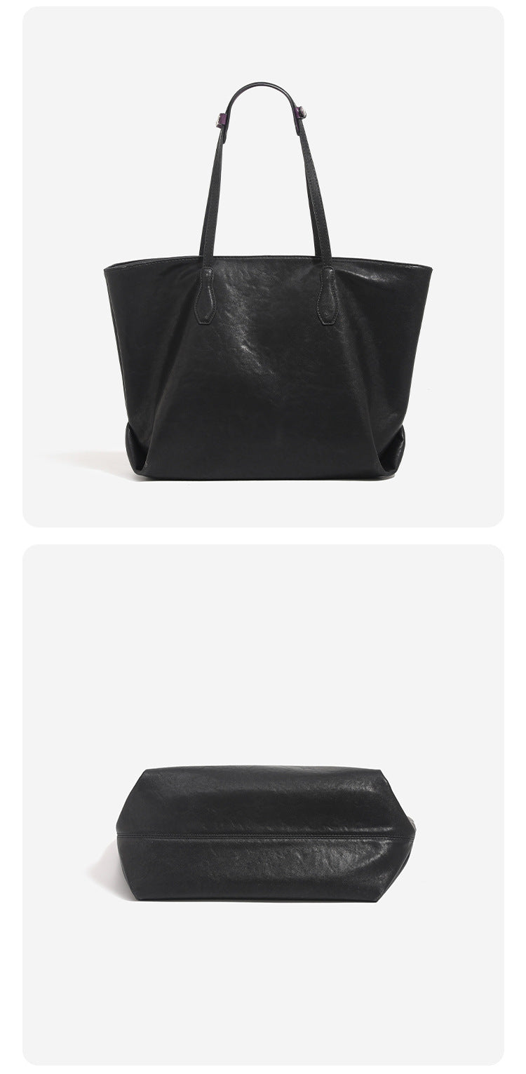 Oversized slouchy leather-look tote bag with long shoulder straps, contrast grey hanging tag, and silver-tone hardware