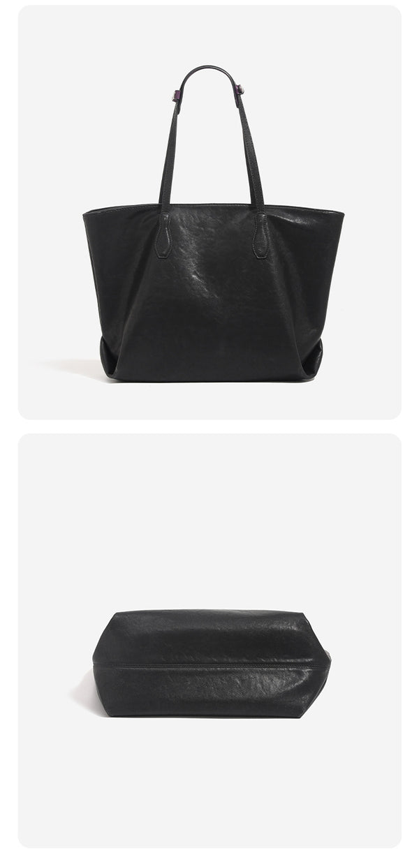 Oversized slouchy leather-look tote bag with long shoulder straps, contrast grey hanging tag, and silver-tone hardware