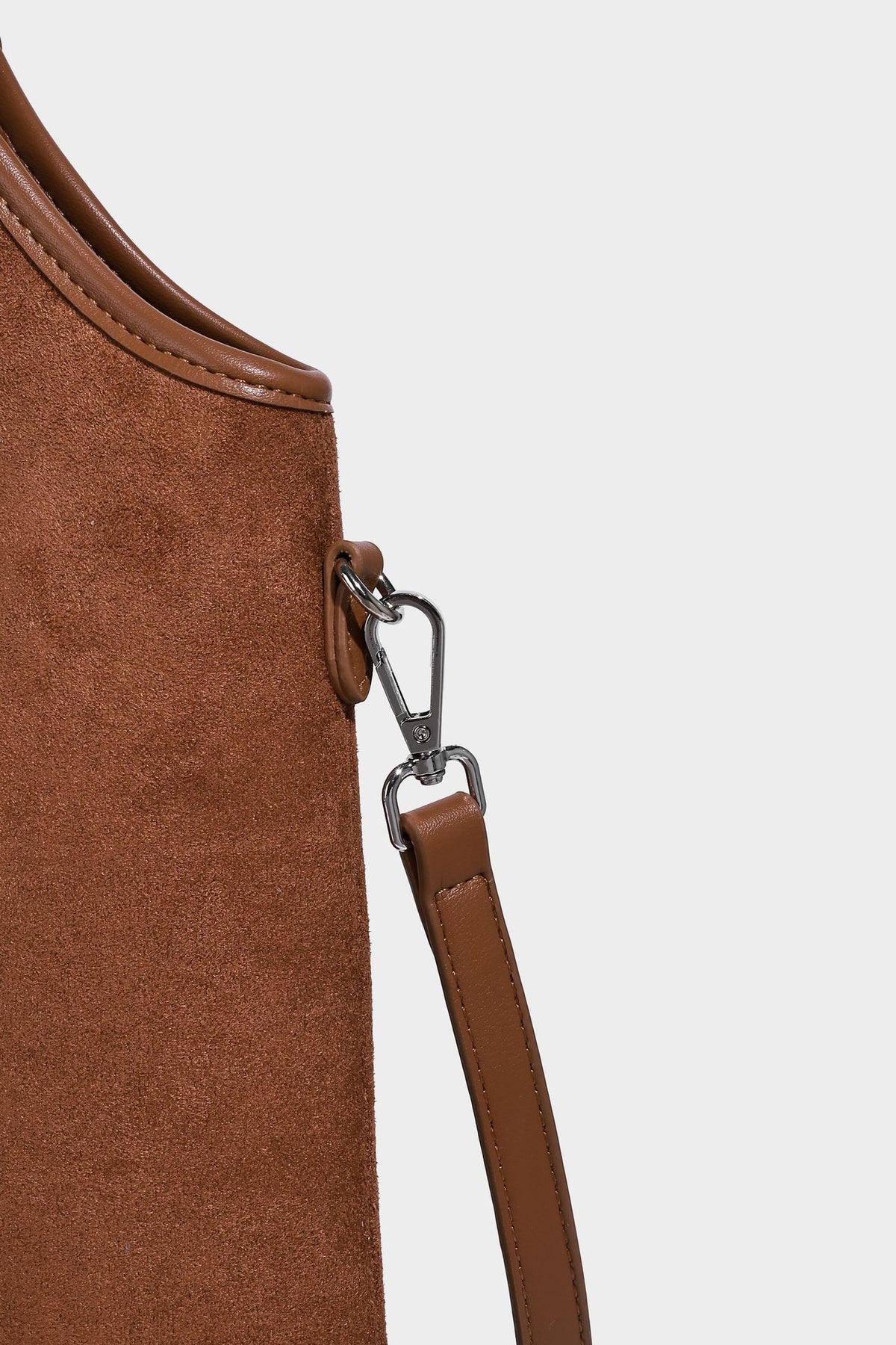 Tote-Bag in warmem Braun mit matter Wildlederoptik, langen Tragegriffen, geprägtem Logo, silberfarbenen Beschlägen und passendem, Detail