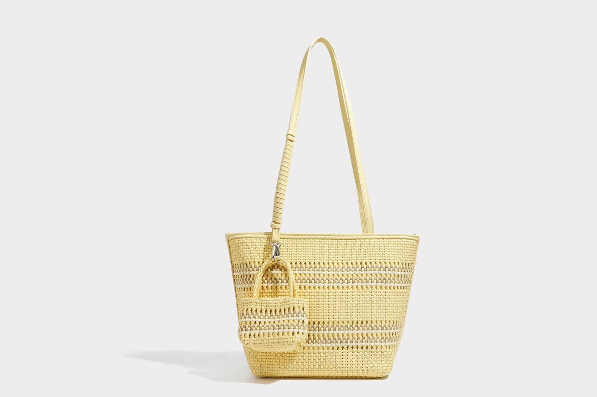 Large structured woven tote bag with striped basket-weave finish, long shoulder straps, and detachable mini pouch charm