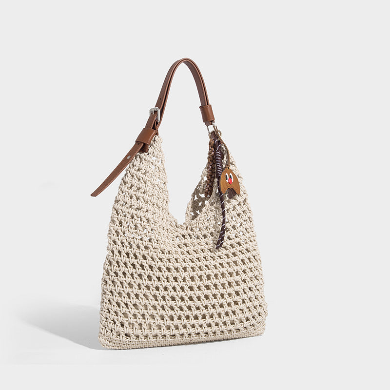 Slouchy open-knit crochet hobo tote bag with leather-look top handle and metal buckle hardware, front view