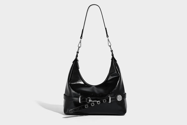 Glossy black slouchy hobo shoulder bag with silver-tone hardware, belt-style grommet strap at base, and long adjustable