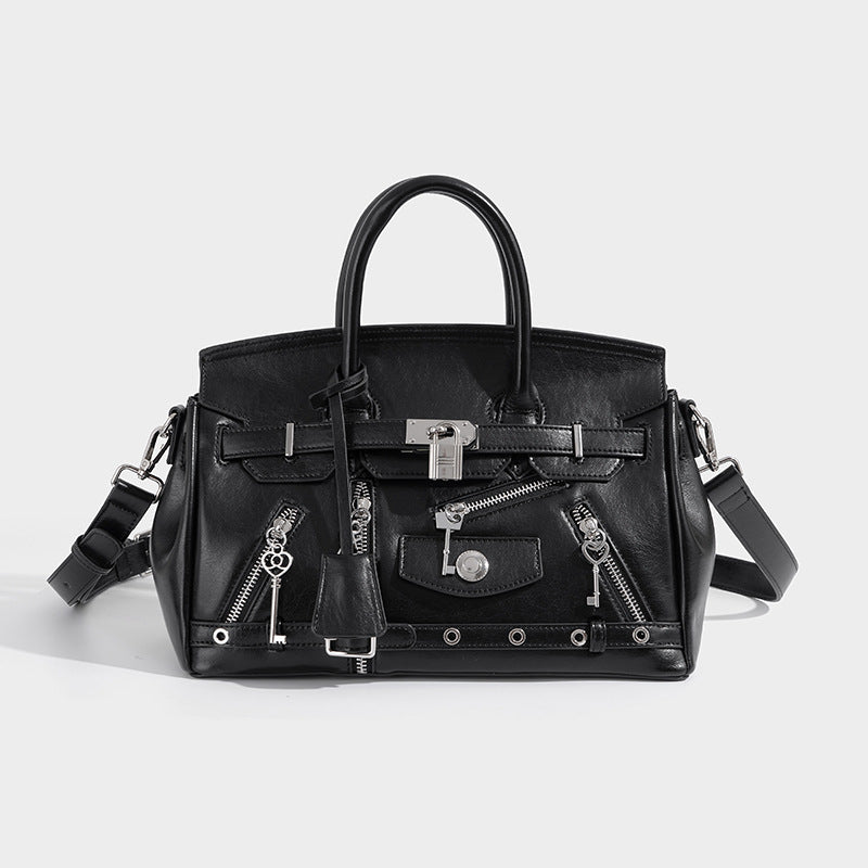 Structured black leather-look satchel bag with silver padlock hardware, front zip pockets, key charms, and top handles