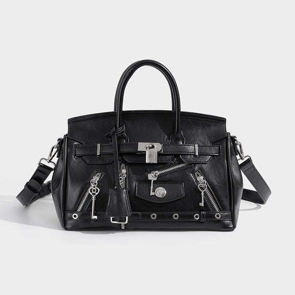 Structured black leather-look satchel bag with silver padlock hardware, front zip pockets, key charms, and top handles