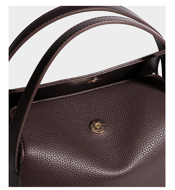 Structured pebbled leather-look shoulder bag with flap top, gold-tone emblem hardware, dual top handles, and detachable