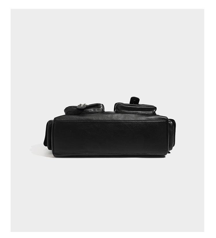 Black leather-look tote bag with silver pyramid studs on handles and front panel, multiple flap and zip exterior pockets