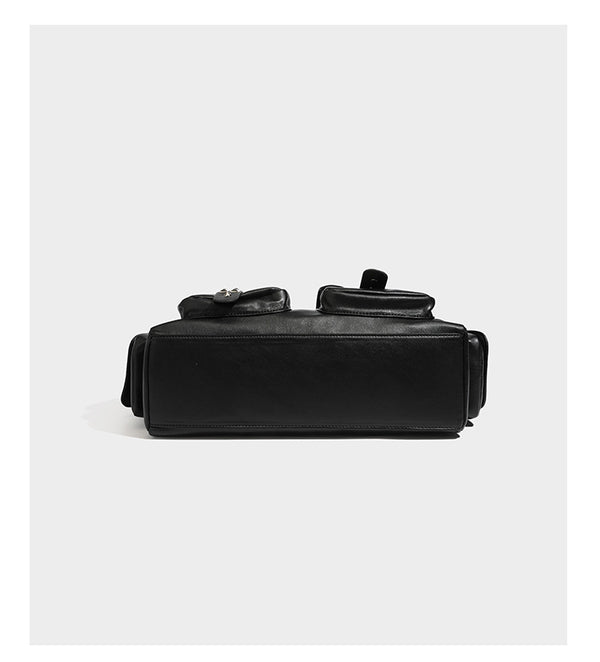 Black leather-look tote bag with silver pyramid studs on handles and front panel, multiple flap and zip exterior pockets
