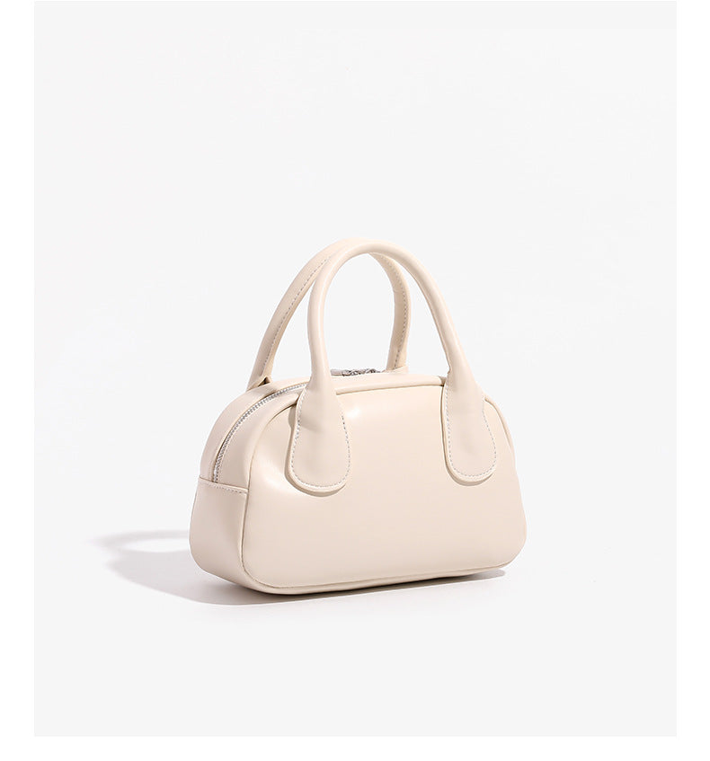 Mini-Handtasche in Kuppelform mit glatter Oberfläche in Lederoptik, zwei Henkeln, Reißverschluss oben, silberfarbenen Metalldetails und herabhängendem