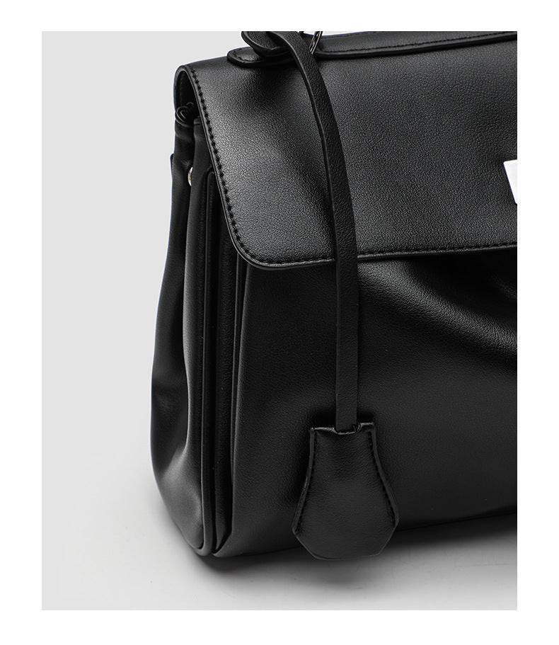 Structured black leather-look flap satchel bag with silver turn-lock hardware and top handle, detail view 24