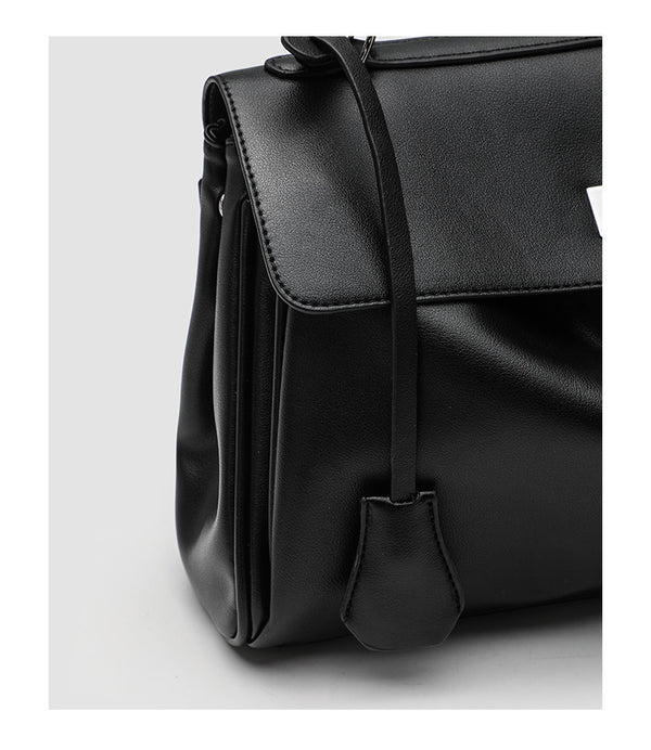 Structured black leather-look flap satchel bag with silver turn-lock hardware and top handle, detail view 24