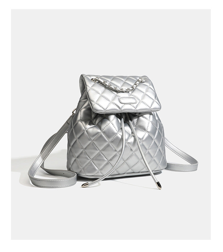 Black diamond-quilted backpack handbag with silver-tone chain flap accent and adjustable shoulder straps, detail view 18