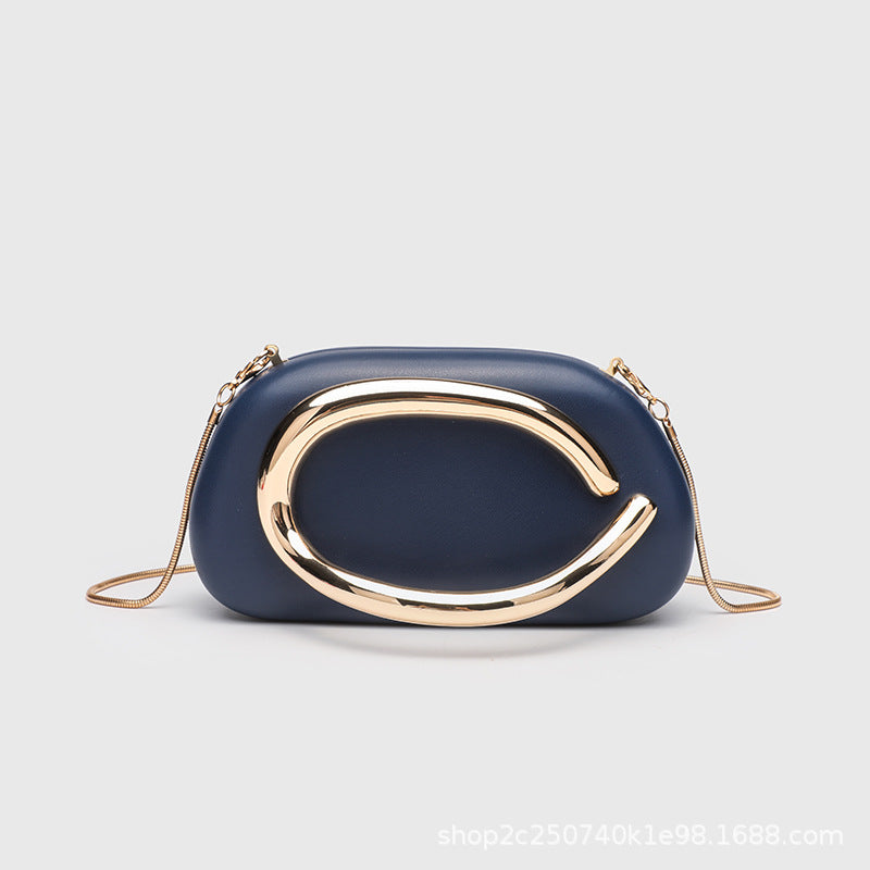 Kleine rechteckige Crossbody-Clutch mit abgerundeten Ecken, oversized poliertem C-förmigem Goldgriff und schmalem Goldkettenriemen, Detailansicht